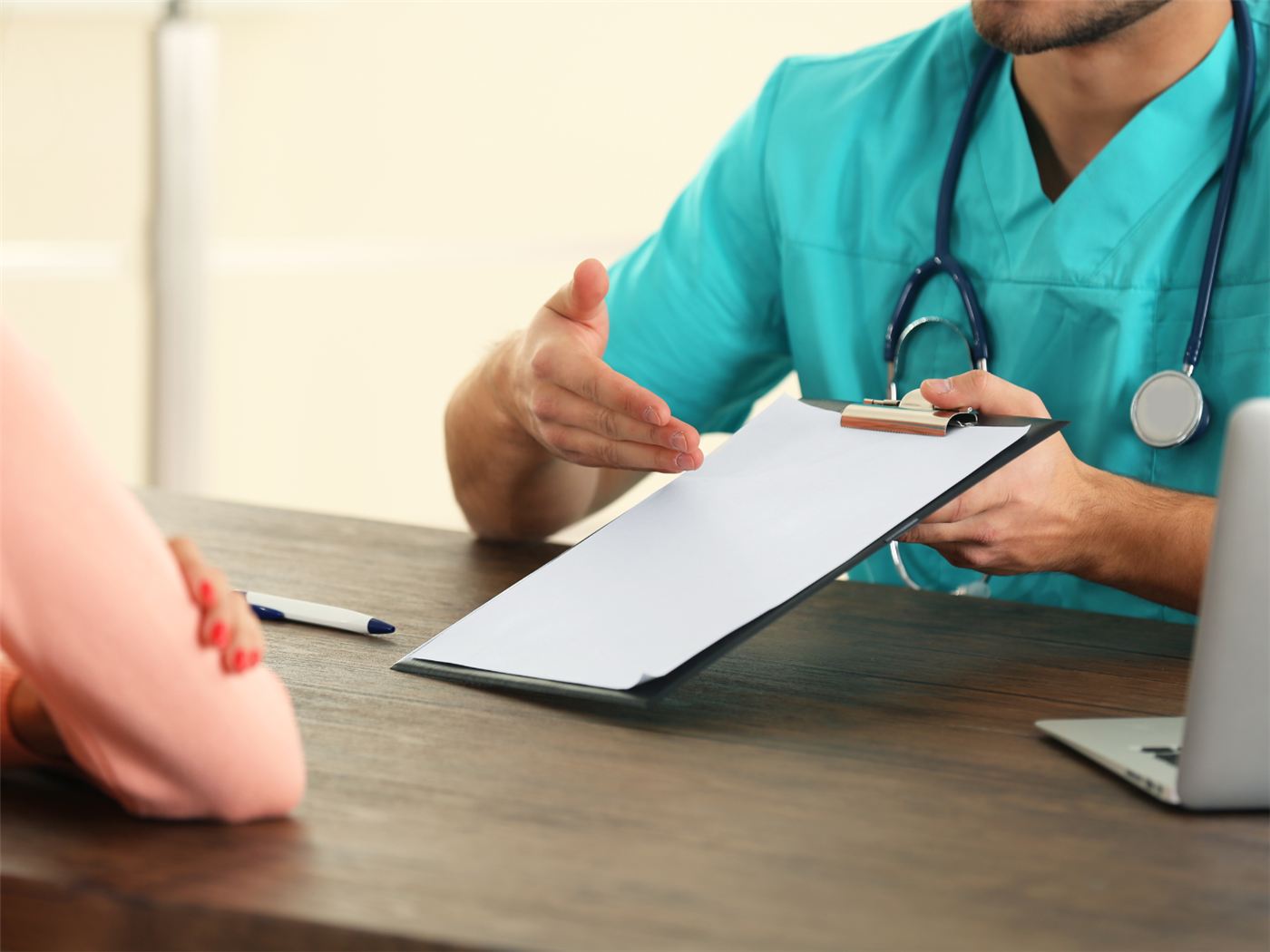A health worker explaining a consent form to a patient before signing